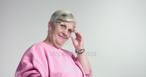 idős nő megérinti a szemüveg és néz felette - Felvétel, videó
