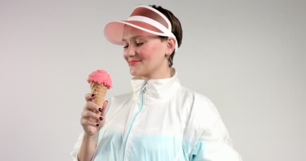 όμορφη γυναίκα στο σκιάδιο τρώει ένα παγωτό - Πλάνα, βίντεο