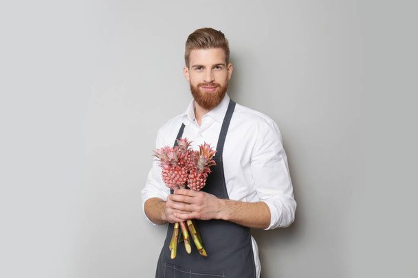 handsome florist with exotic pineapples - Fotografie, Obrázek