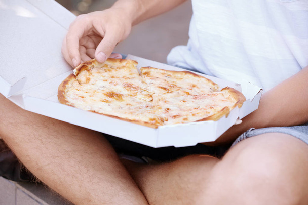 Man with pizza on street - Foto, imagen