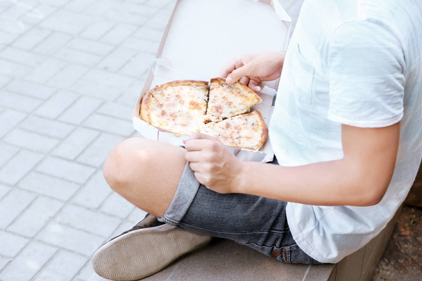 Man with pizza on street - 写真・画像