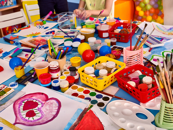 Kindergartentische und -stühle in Regalen für Spielsachen. - Foto, Bild