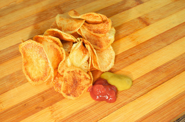 Порція смаженої круглої картоплі з кетчупом та гірчицею
 - Фото, зображення