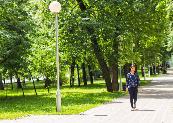 Belle jeune femme marchant dans le parc vert d'été
 - Photo, image