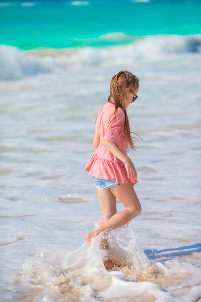 Adorable little girl at beach having a lot of fun in shallow water - Fotoğraf, Görsel
