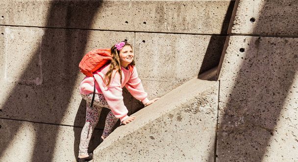 幸せな、うれしそうな笑顔の素敵なビュー晴れた春の日にコンクリート壁にハイキング少女 - 写真・画像