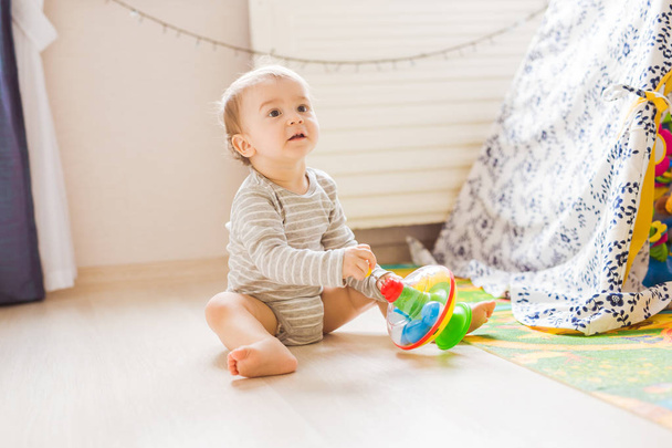 Милый мальчик играет с игрушкой в помещении
 - Фото, изображение