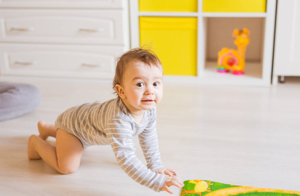 Retrato de gatear divertido bebé niño dentro de casa
 - Foto, Imagen