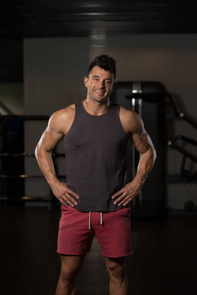 Homem de Undershirt Flexing Músculos
 - Foto, Imagem