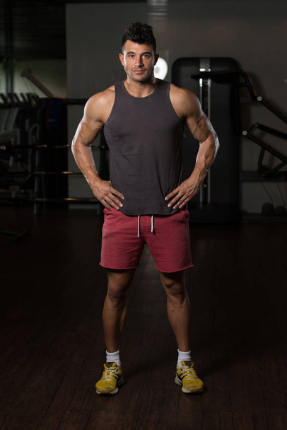 Fitness Model In Undershirt Flexing Muscles - 写真・画像
