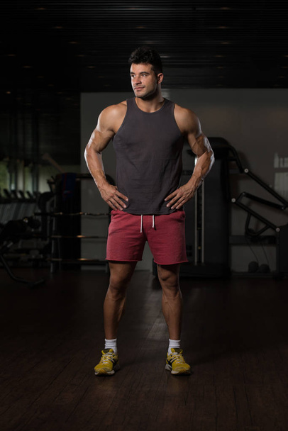 Fitness Model In Undershirt Flexing Muscles - Fotografie, Obrázek