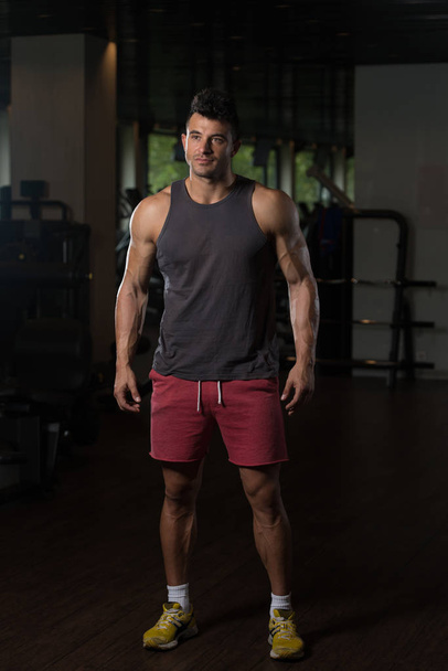 Fitness Model In Undershirt Flexing Muscles - Valokuva, kuva