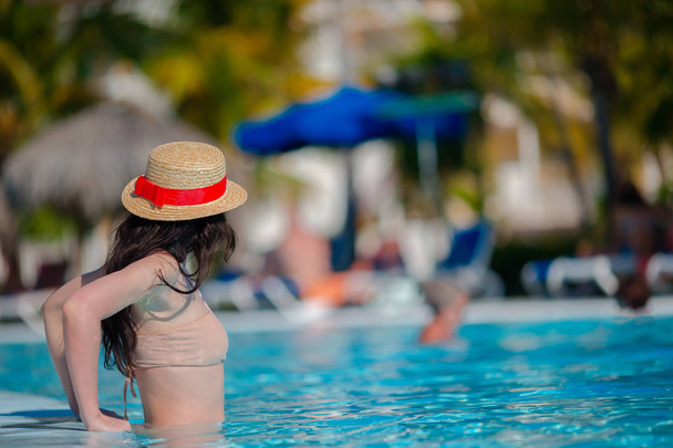 Bella giovane donna rilassante in piscina. Ragazza felice in piscina all'aperto in hotel di lusso
 - Foto, immagini