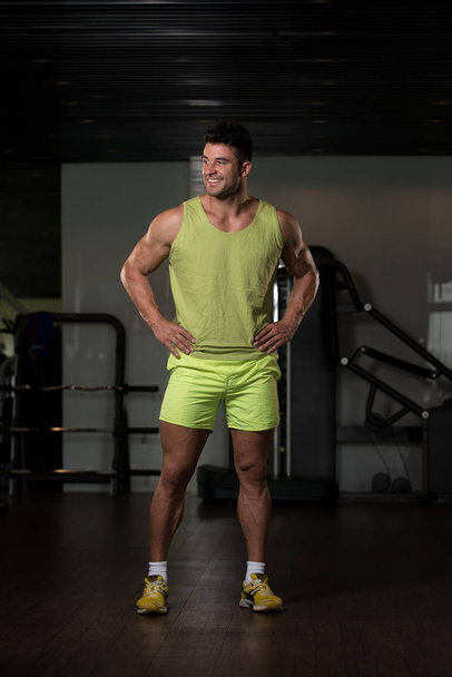 Strong Man in Green T-shirt Background Gym - Foto, afbeelding