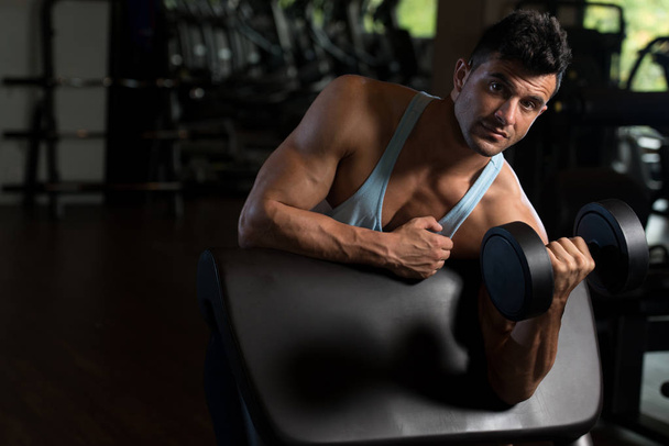 Biceps Exercise With Dumbbell in a Fitness Center - Foto, imagen