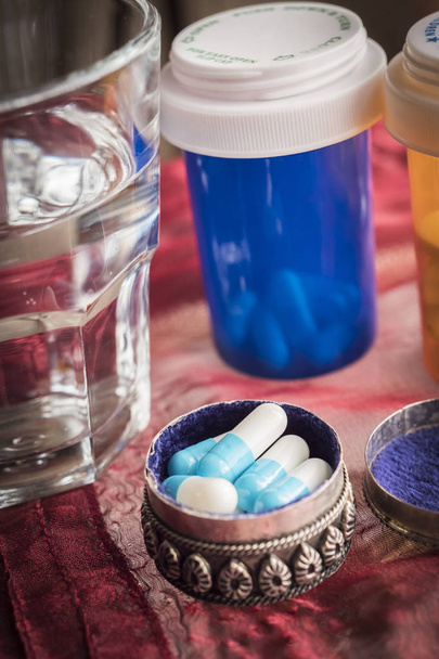 Fémes pirulásdoboz fehér tabletták, valamint a víz-glass - Fotó, kép
