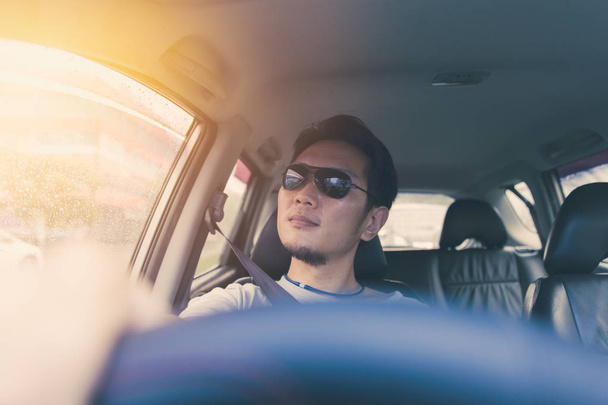 Azjatycki chiński tajski człowiek mężczyzna ware czarne słońce szkła jazdy samochodem w upalny letni dzień podróży. - Zdjęcie, obraz
