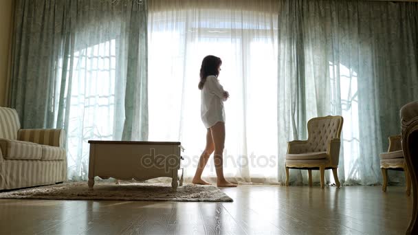 Femme bouleversée en chemise allant et revenant le long de la fenêtre d'un appartement confortable
 - Séquence, vidéo