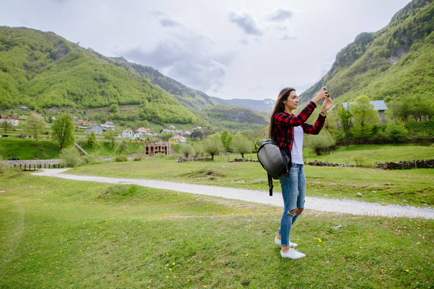 woman with smartphone backpacking in mountains - Foto, Imagem