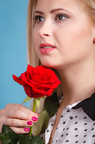 Woman holding red rose flower on blue - Фото, изображение