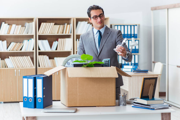 Man verhuisd kantoor met doos en zijn bezittingen - Foto, afbeelding