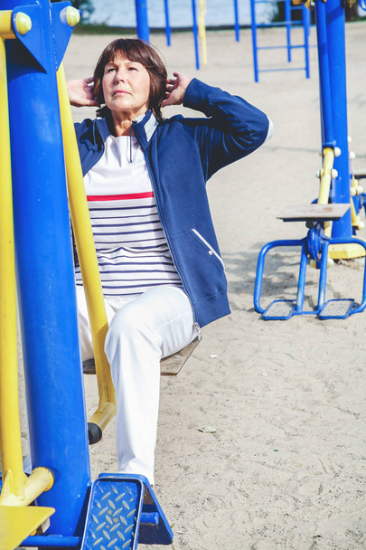 Elderly woman playing sports in street simulator - Foto, imagen