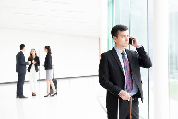 Путешествующий бизнесмен звонит по смартфону в строительном коридоре
 - Фото, изображение