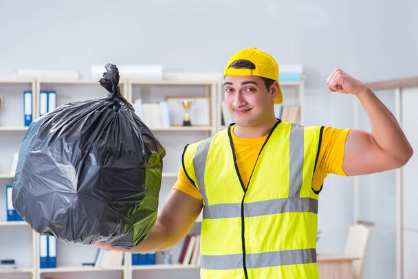 Man cleaning the office and holding garbage bag - Photo, image