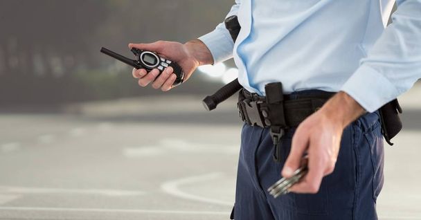 Guardia de seguridad inferior del cuerpo con walkie talkie contra la calle borrosa
 - Foto, imagen