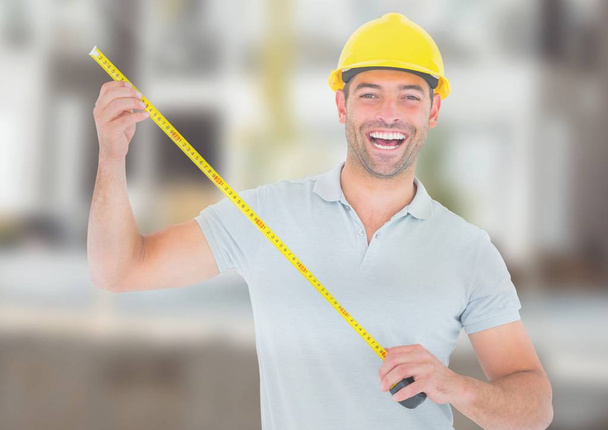 Construction Worker with measuring tape in front of construction site - Photo, Image