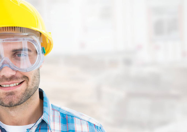Construction Worker with eye protection goggles in front of construction site - Foto, afbeelding
