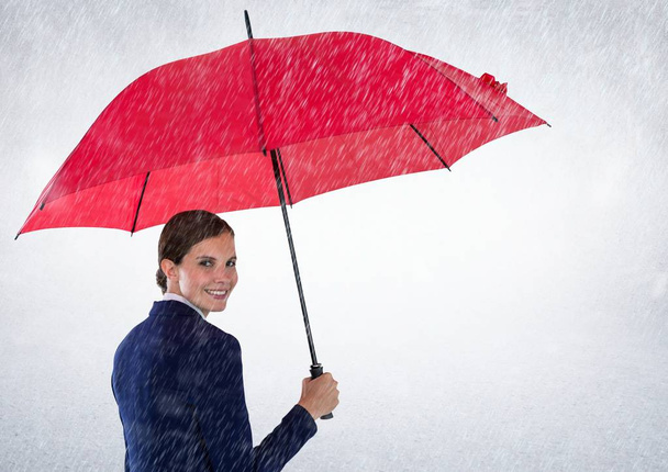 Business woman looking over shoulder with umbrella against white background and rain - Fotografie, Obrázek