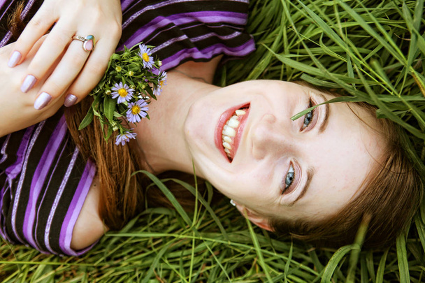 young smiling woman on the grass - Фото, изображение
