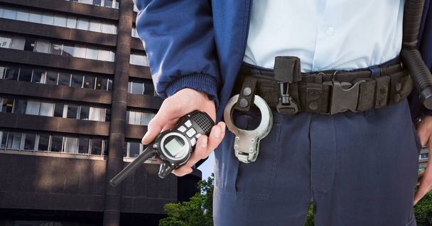 Midsection of security guard holding radio in city - Foto, imagen
