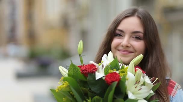 Portrait of smiling young woman smelling flowers - Metraje, vídeo