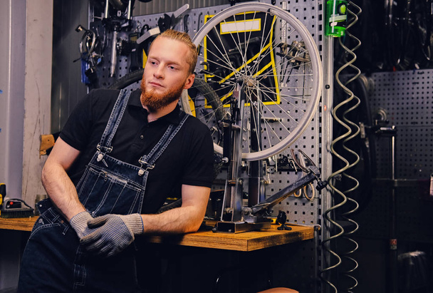 Mecânico em uma oficina com peças de bicicleta
 - Foto, Imagem