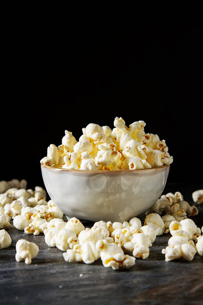 Salted popcorn in a cup. Dark background. Selective focus. Fast  - Photo, image