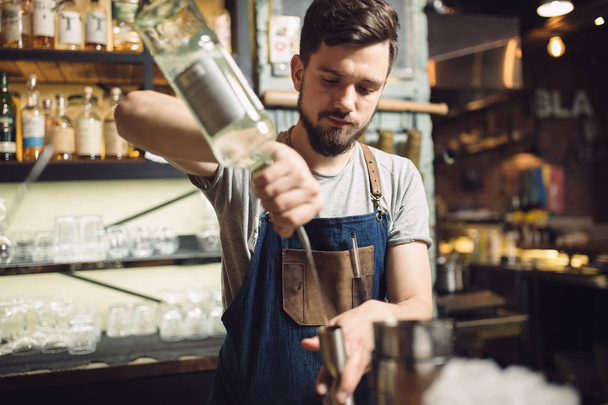Young male bartender preparing an alcohol cocktail - Фото, зображення