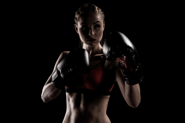 sportswoman exercising in boxing gloves - Foto, afbeelding