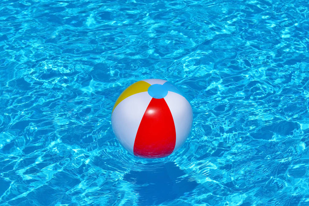 Colorful inflatable ball floating in swimming pool - Fotografie, Obrázek