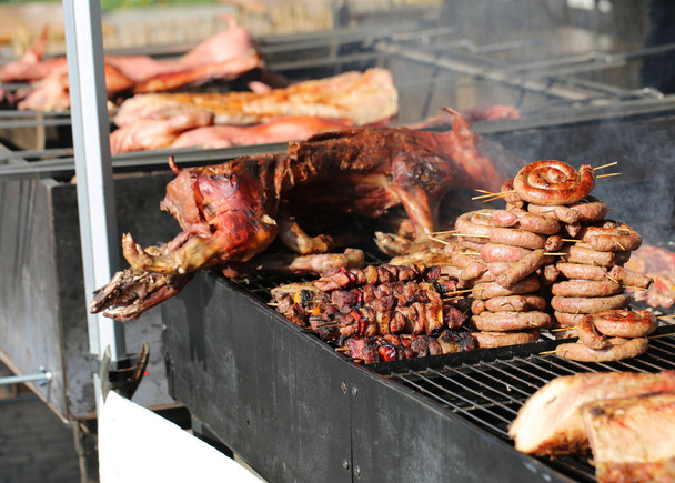 comida callejera con cerdo asado y barbacoa de carne cocida y salchichas
 - Foto, imagen