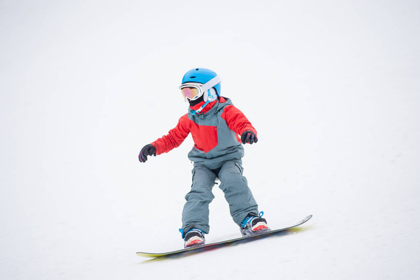 Snowboardzista chłopiec jazda na stoku - Zdjęcie, obraz