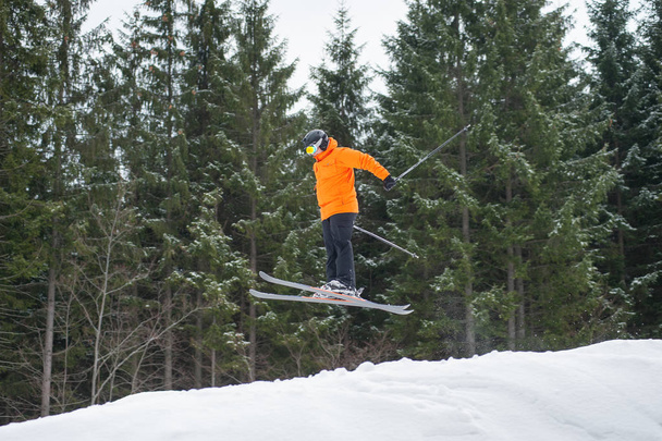 Hombre esquiador volador en salto desde la ladera de las montañas
 - Foto, imagen