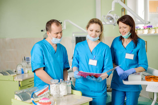 Trois dentistes regardant le dossier à la clinique de stomatologie
 - Photo, image