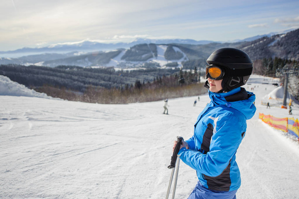 Young beautiful female skier on the middle of ski slope - Photo, Image