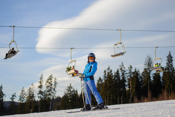 Sciatrice contro skilift e bosco in una giornata di sole
 - Foto, immagini
