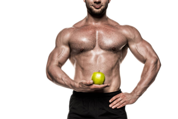 Muscular sportsman holding apple 4 - Photo, Image