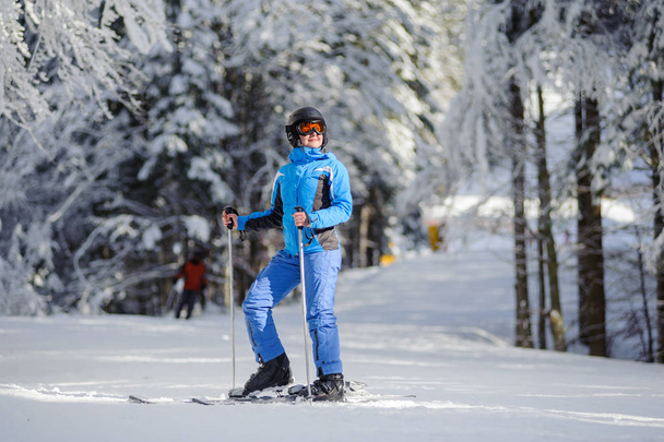 Happy woman skier on a ski slope in the forest - Photo, Image