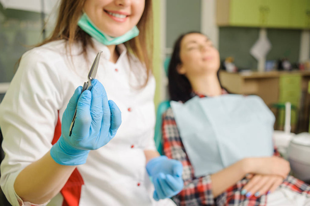 Dentista mujer sosteniendo herramienta dental. Ortodoncia Tratamiento
 - Foto, Imagen