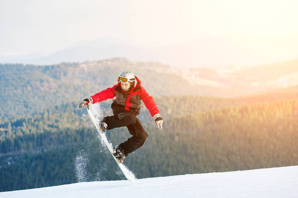 Male boarder on his snowboard at winer resort - Photo, Image